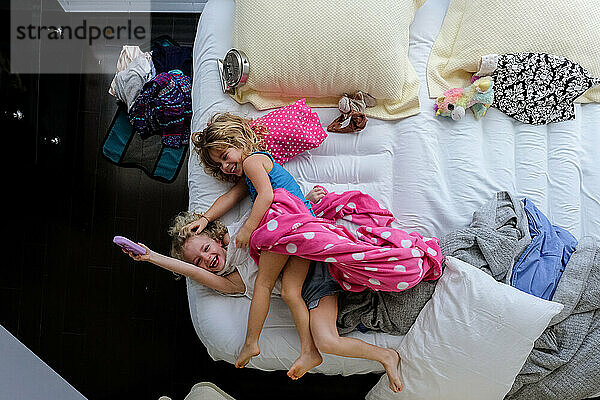 Schwestern liegen zusammen auf einer aufblasbaren Matratze und lachen und sind glücklich zusammen