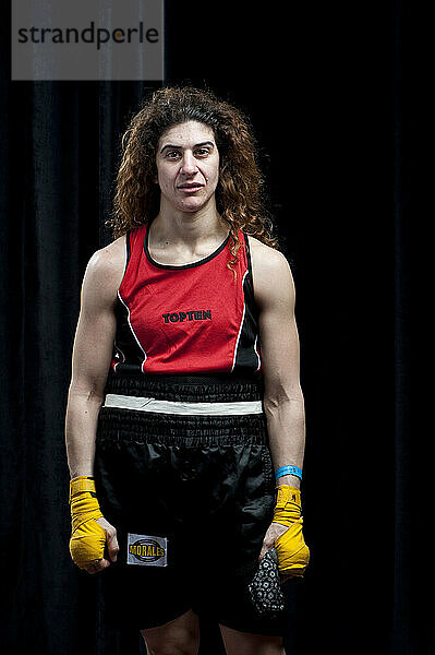 Eine Boxerin mit langen kastanienbraunen Haaren und gelben Handbandagen steht wenige Minuten nach ihrer Niederlage in ihrer Halbfinalrunde bei den Canadian Amateur Boxing Championshi für ein Porträt zur Verfügung