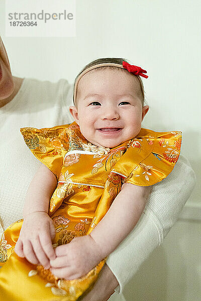 Babymädchen trägt traditionelle chinesische Kleidung für besondere Anlässe