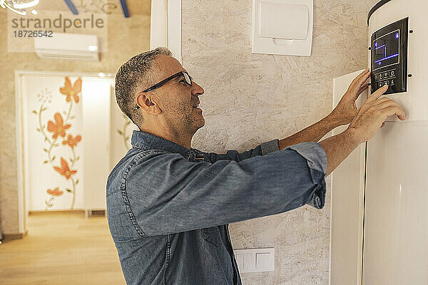 Mann stellt Smart-Home-Thermostat ein