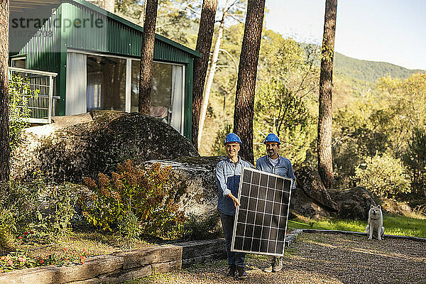 Photovoltaik-Techniker tragen Solarpanel zusammen