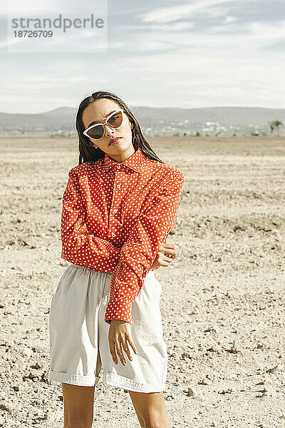Junge modische Frau mit Sonnenbrille in der Wüste