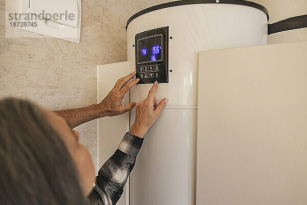 Mann und Frau stellen Smart-Home-Thermostat ein