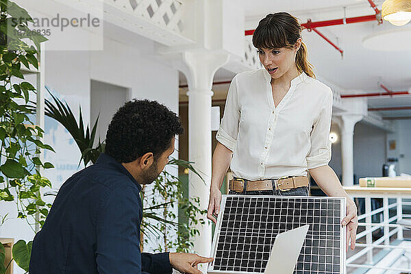 Geschäftsmann und Geschäftsfrau sprechen im Büro über Solarpanel