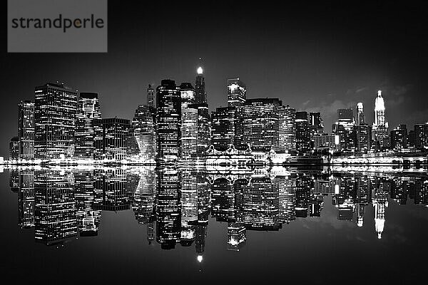 New York bei Nacht mit Spiegelung im Wasser in schwarzweiß