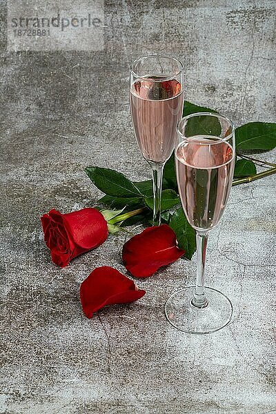 Zwei Gläser Champagner und eine Rose auf einem weißen Hintergrund und Kopierraum Valentinstagssymbol
