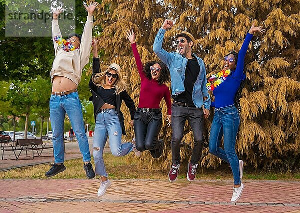Gruppe multiethnischer Freunde  die in einem Park feiern  Verschiedene junge Leute  die bei einer Sommerparty vor Freude springen  Happy Hour  Mittagspause und Jugendkonzept
