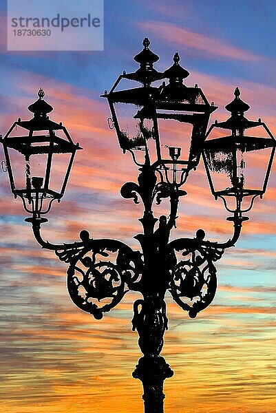 Symbolfoto  Silhouette einer Straßenlaterne gegen Abendhimmel nach Sonnenuntergang