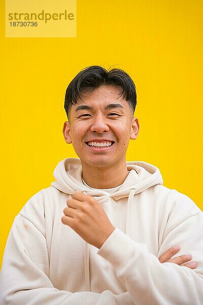 Porträt eines gut aussehenden südkoreanischen asiatischen Mannes in einfacher Kleidung  lächelnd  isoliert auf gelbem Hintergrund  lächelnd und Spaß habend
