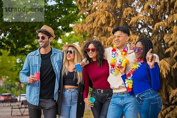 Gruppenbild von multiethnischen Freunden  die eine Party im Park feiern  Verschiedene junge Leute mit Biergläsern bei einer Sommerparty  Happy Hour  Mittagspause und Jugendkonzept