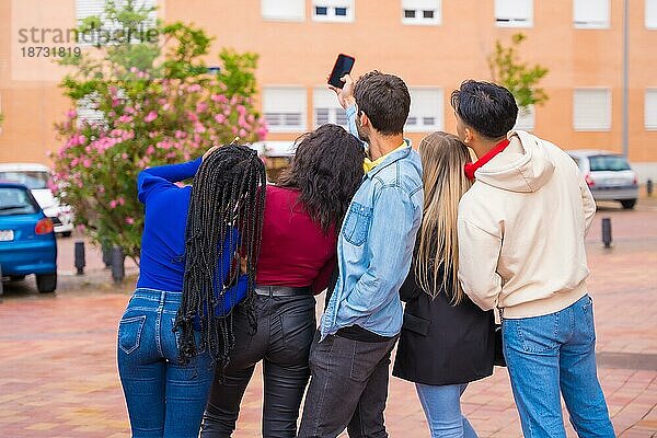 Gruppe multiethnischer Freunde  die durch den Universitätscampus spazieren und Spaß daran haben  ein Selfie zu machen  junges Millennial-Handy-Technologiekonzept