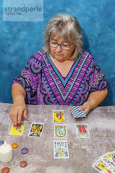 Ältere weißhaarige Frau pythoness legt Tarotkarten