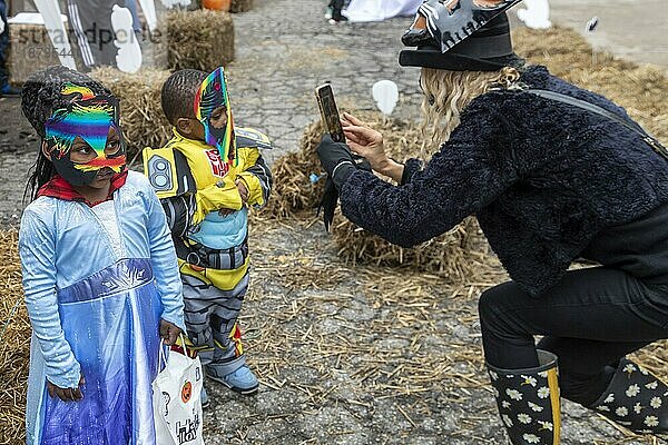 Detroit  Michigan  Eine Frau fotografiert Kinder in ihren Kostümen bei Alger in the Alley  einem Halloween Festival in der Gasse hinter dem Alger Theater