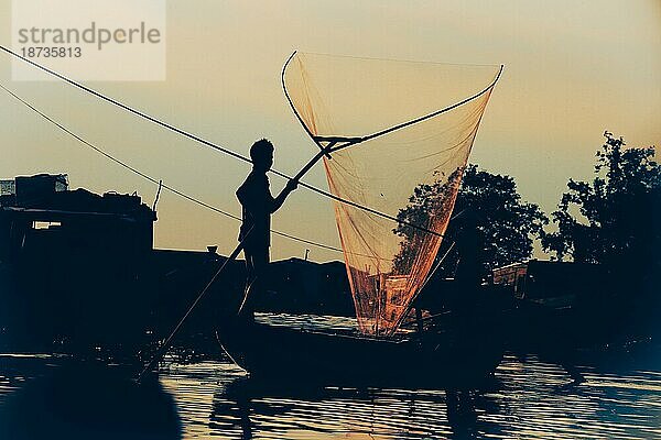 Silhouette eines Fischers mit einem Fischernetz im Fluss Hau in Vinh Long  Vietnam  Asien