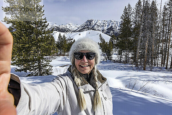 USA  Idaho  Sun Valley  Seniorin macht Selfie in verschneiten Bergen