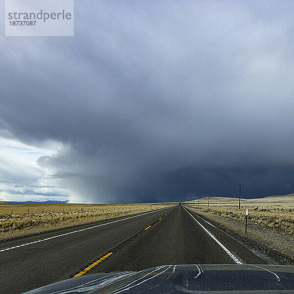 USA  Nevada  McDermitt  Highway führt zu Gewitterwolken am Horizont