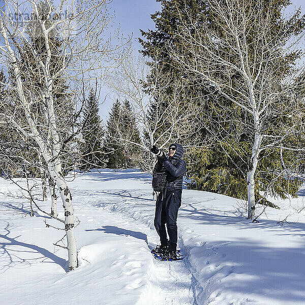 USA  Idaho  Sun Valley  Seniorin mit Schneeschuhen beim Wandern im verschneiten Wald