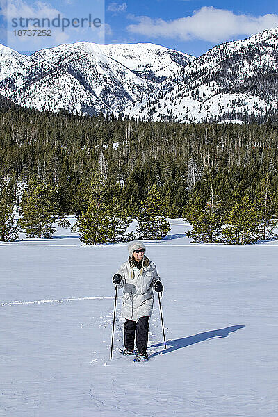 USA  Idaho  Sun Valley  Seniorin mit Schneeschuhen beim Wandern in den Bergen