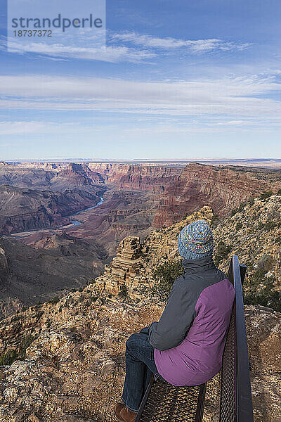 USA  Arizona  Rückansicht einer Touristin  die auf einer Bank im Grand Canyon National Park sitzt