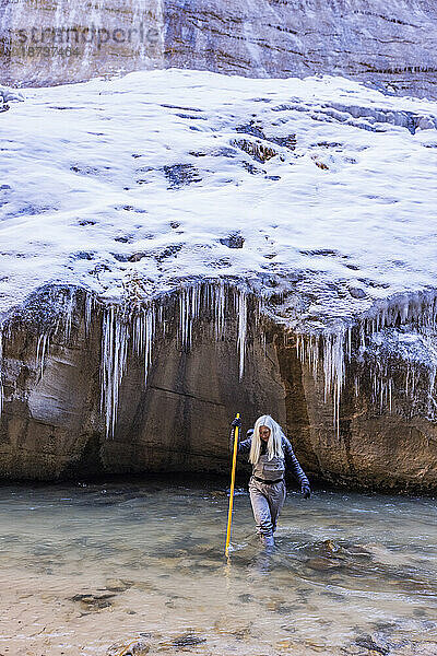 USA  Utah  Springdale  Zion-Nationalpark  Seniorin überquert den Fluss beim Wandern in den Bergen