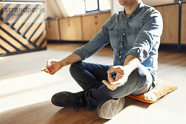 Handsome hispanischen Mann trägt Jeans lässigen Hemd sitzen auf dem Boden zu Hause entspannen  tun Meditation Geste mit den Fingern. Yogakonzept