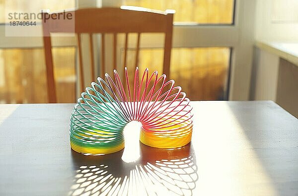 Anti Stress Magie Ring Frühling Regenbogen bounce Spielzeug auf dem Tisch in sonnigen Raum zu Hause  selektiven Fokus. Stressabbau und Anti Angst Spielzeug Konzept