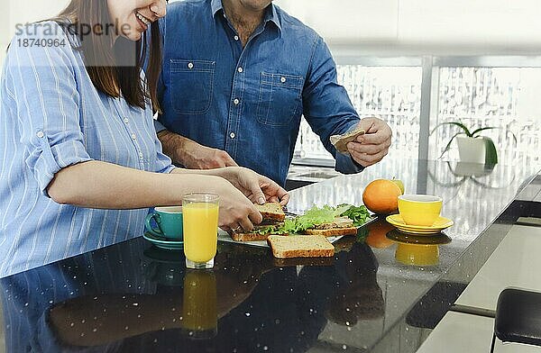 Mann im Gespräch mit seiner Frau Kochen gesundes Essen genießen Vorbereitung romantisches Abendessen in der Küche. Paar bereitet Abendessen vor. Gesundes Essen  Diät. Gemeinsam kochen in der modernen Küche