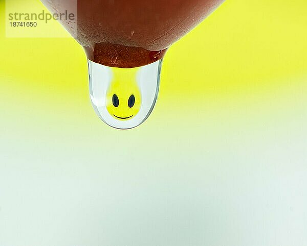 Makro eines fröhlichen Smileys  das sich in einem Wassertropfen bricht