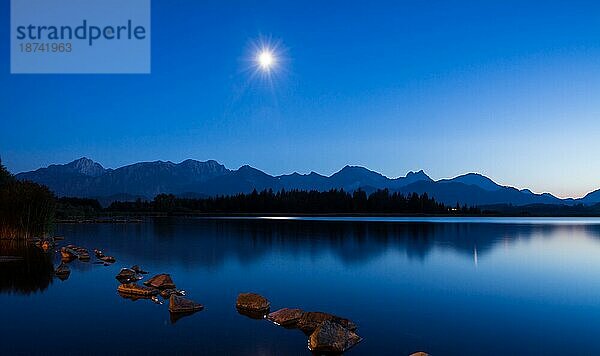 Mondlicht während der blaün Stunde am Hopfensee (Bayern) Deutschland