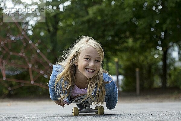 Mädchen (10) liegt auf Skateboard  Kiel  Schleswig-Holstein  Deutschland  Europa