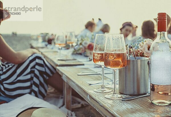 Leckeres Essen und Blumen für ein Sommer oder Frühlingspicknick im Freien. Mittagessen am Strand in romantischen Farben