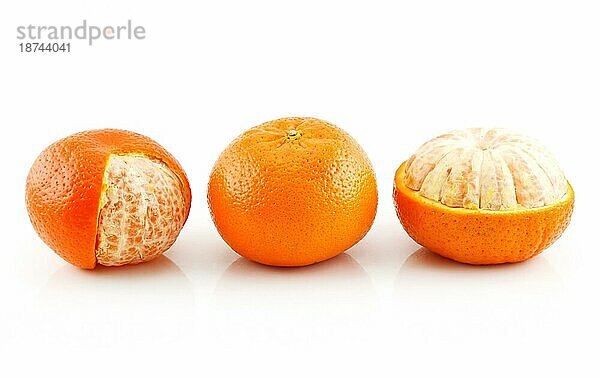 Drei reife Mandarinenfrüchte vor weißem Hintergrund
