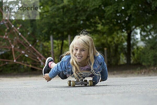 Mädchen (10) liegt auf Skateboard  Kiel  Schleswig-Holstein  Deutschland  Europa