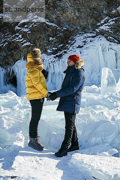 Glückliches Paar auf dem zugefrorenen Winter Baikalsee. Transparentes Eis. Reisen im Winter  aktive Erholung  Sport  Urlaub