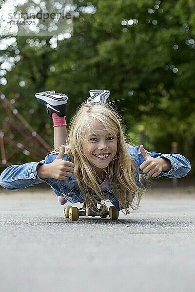 Mädchen (10) liegt auf Skateboard  Kiel  Schleswig-Holstein  Deutschland  Europa