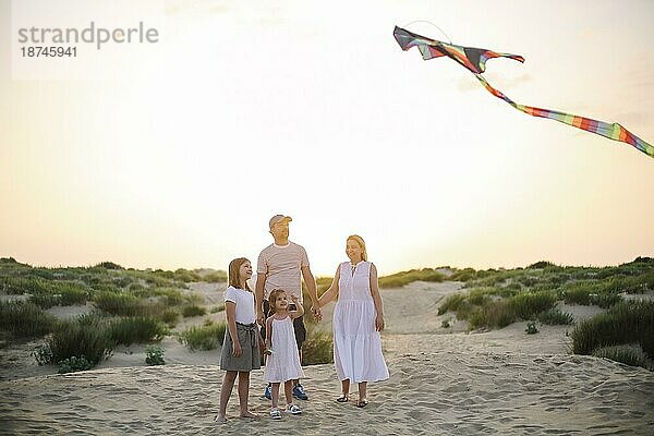 Glückliche Familie mit Eltern und Kinder spielen zusammen mit Schlangen auf einem Strand Urlaub. Sommer Glück Konzept mit Mixed race Menschen  die Spaß am Meer