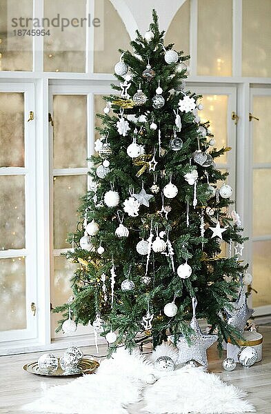 Grüner  mit goldenen Kugeln geschmückter Nadelbaum am Weihnachtstag zu Hause