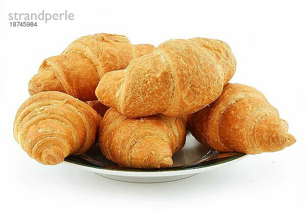 Gruppe von Croissants auf Untertasse vor weißem Hintergrund