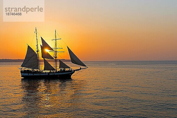 Romantischer Sonnenuntergang mit Segelschiff in Griechenland