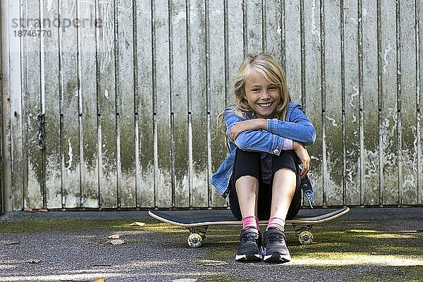 Mädchen (10) sitz auf Skateboard  Kiel  Schleswig-Holstein  Deutschland  Europa