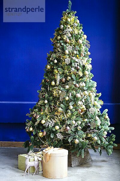 Grüner  mit goldenen Kugeln geschmückter Nadelbaum am Weihnachtstag zu Hause