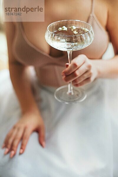 Von oben Weichzeichner der anonymen Frau mit Glas Pokal von sprudelnden Champagner genießen Bankett