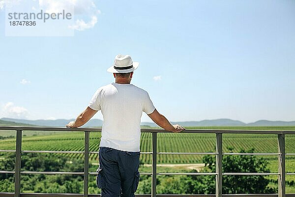 Glücklicher Winzer mit Hut bei einer Weinprobe in einem Weinberg im Sommer. Sommerurlaub Konzept