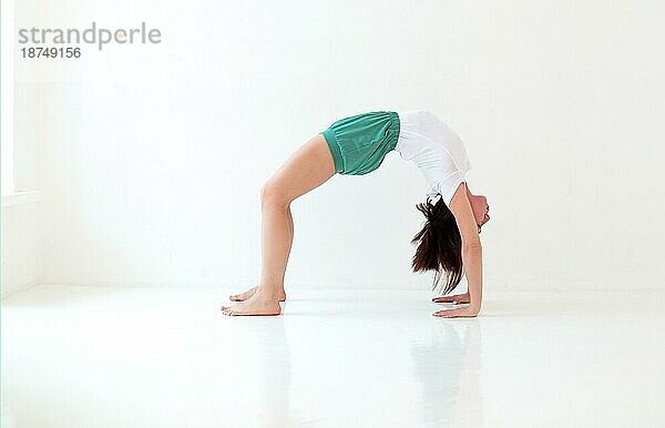 Seitenansicht einer ruhigen Frau in Sportkleidung  die Yoga in einer Pose praktiziert  während sie auf den Armen balanciert und wegschaut