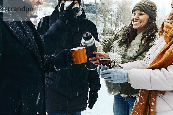 Menschen in einem Wintersportort im Winterurlaub. Freunde entspannen sich  trinken heißen Kaffee. Pause nach Winteraktivität. Glückliche Ferien im Schnee Berg am See