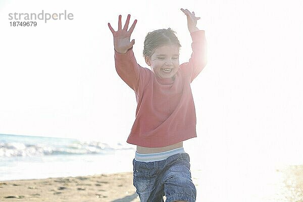 Nettes lächelndes kleines Mädchen  das am sonnigen Strand läuft  glückliches kleines Mädchen  das Zeit am Sommerstrand genießt