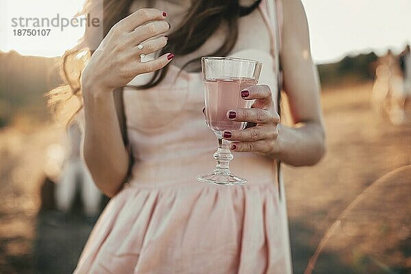 Unerkennbare Frau in Kleid genießt frischen rosa Saft in sonnigen Morgen auf dem Lande