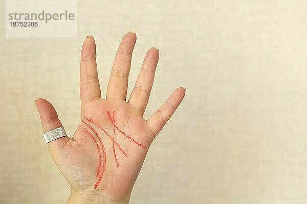 Nahaufnahme einer weiblichen Handfläche mit Lebenslinien  gezeichnet mit rotem Filzstift  vorhellbeigem Hintergrund  Platz für Text. Palmistry  Chiromantie und Handlesen Konzept