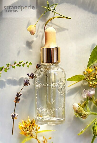 Draufsicht auf Glasflasche mit aromatischen ätherischen Ölen für Spa Sitzung in der Nähe von frischen Blumen auf weißem Hintergrund platziert