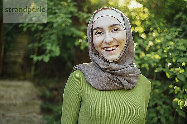 Schöne freudige Teenager High School Mädchen trägt bunte muslimische Kleidung mit Spaß im Freien